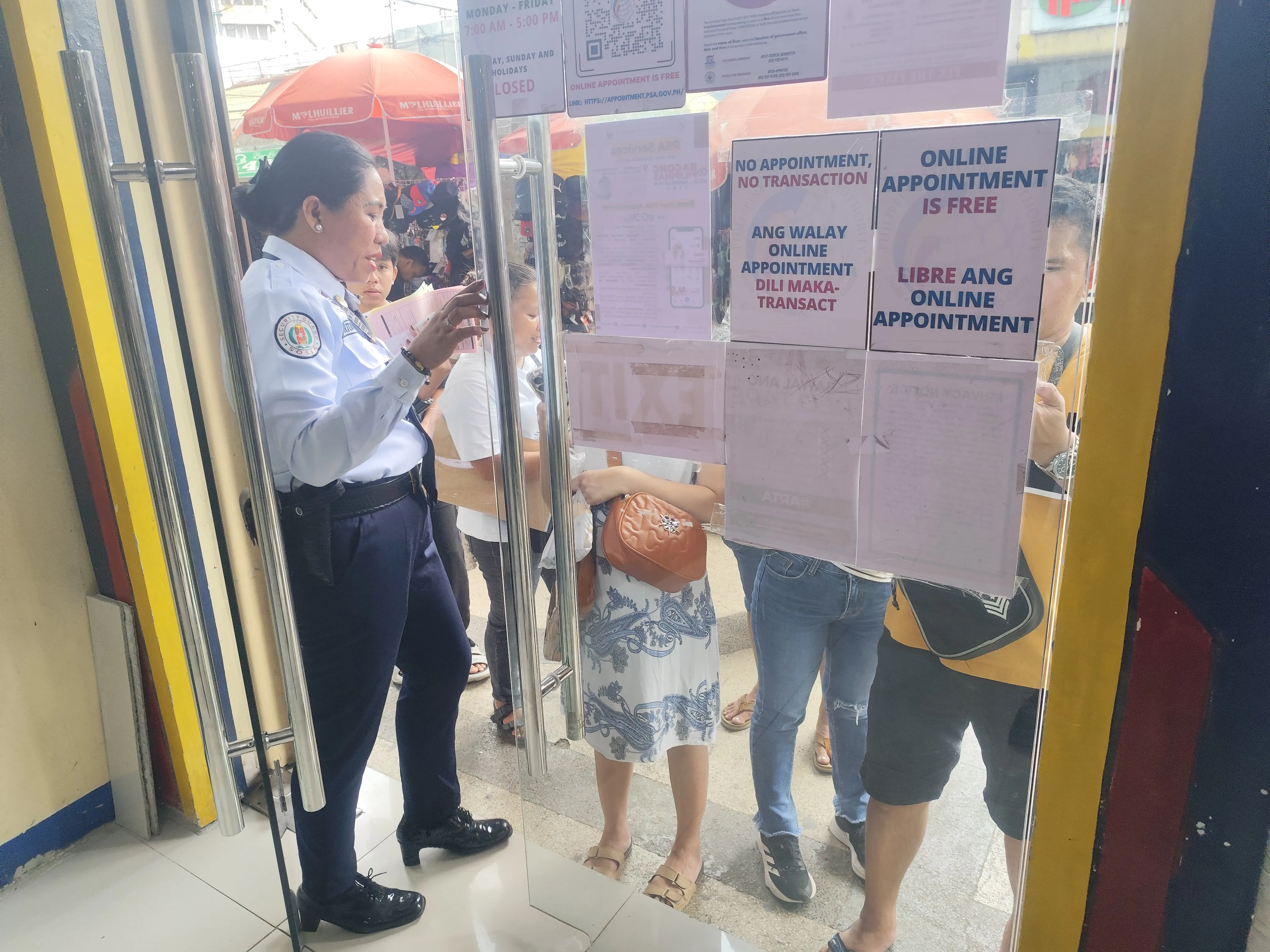 PSA CRS Cebu City Outletの入口で制服を着た女性警備員が利用者の予約確認をしている様子
