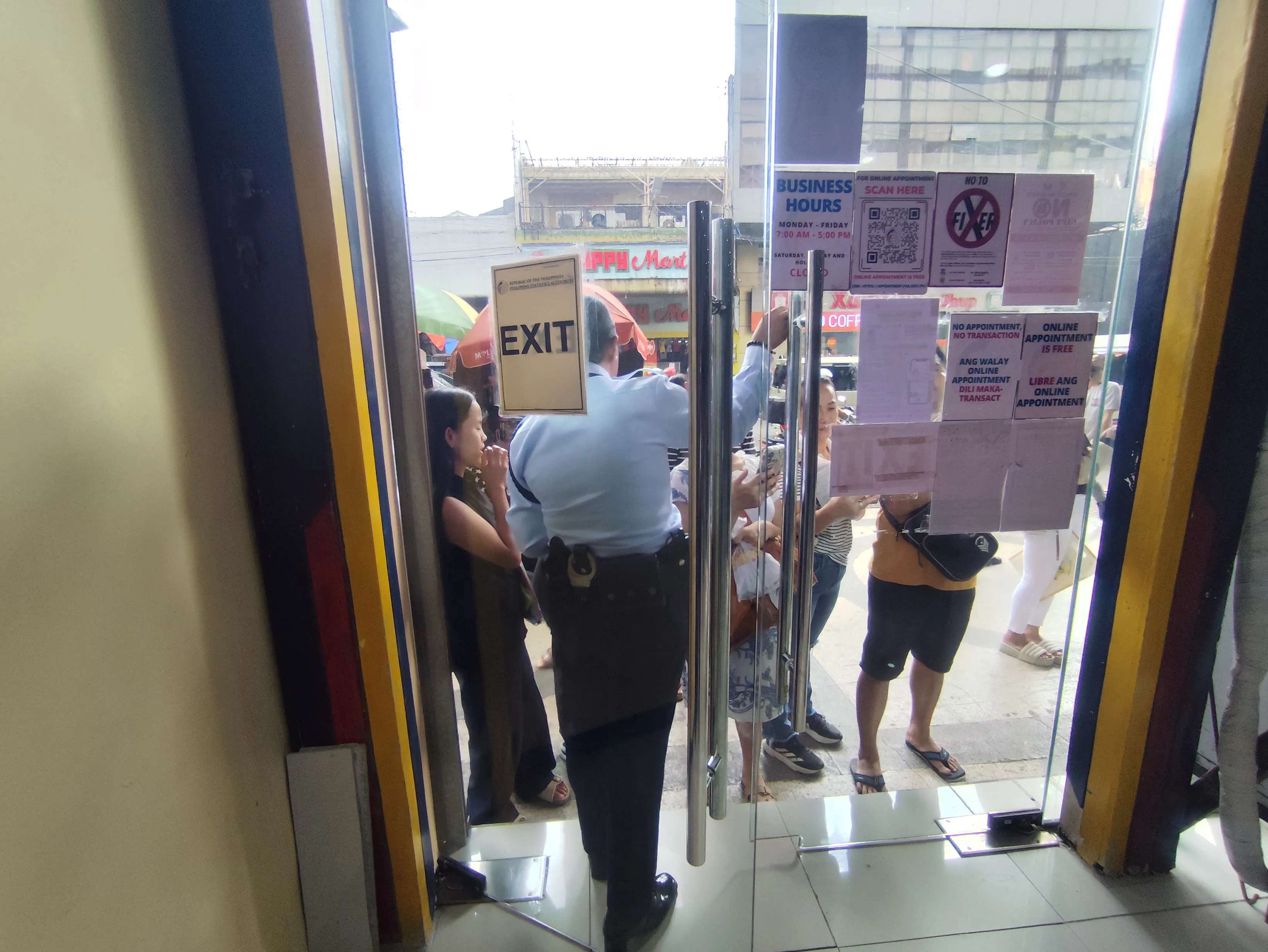 PSA CRS Cebu City Outlet入口のEXITドア。複数の掲示物と「NO APPOINTMENT NO TRANSACTION」の張り紙が見える